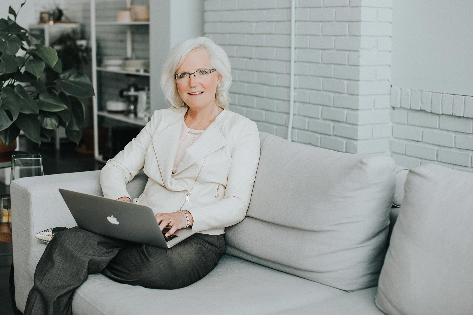 Photograph of Nancy M. Dahl sitting on the couch with her computer.